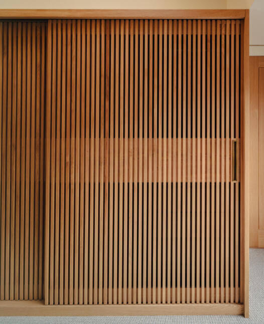 Bespoke solid oak slatted sliding wardrobe doors Large sliding slatted wardrobe doors made from hand-selected European oak and premium veneer with a naturally patinated brass pull handle. made by Fundi Joinery in Edinburgh, Scotland